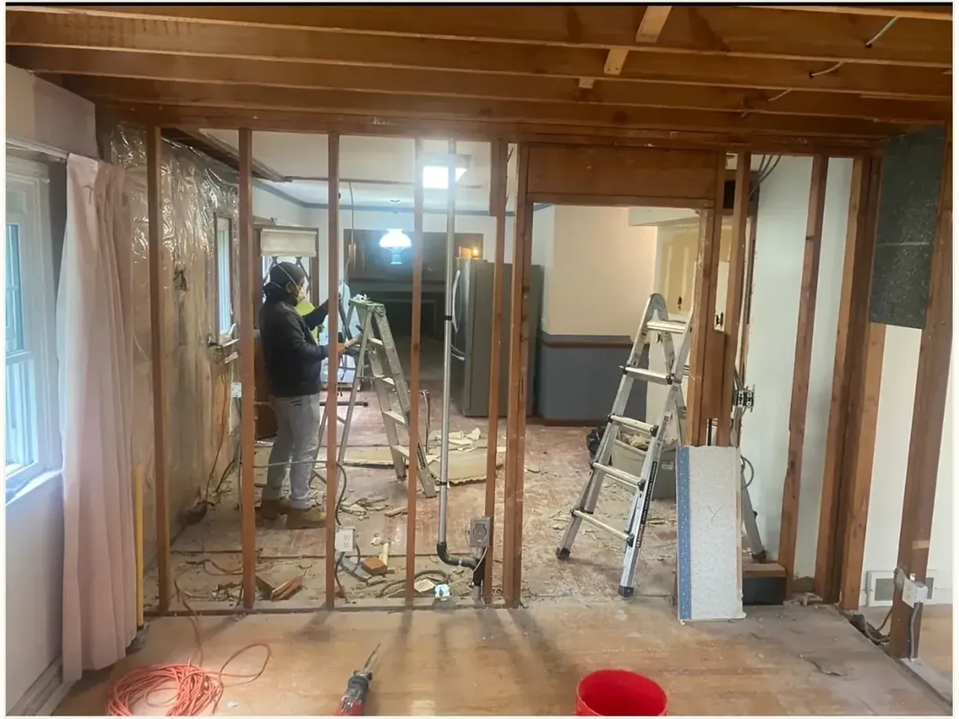 Her own kitchen mid-renovation, stripped back to the studs with the ceiling open